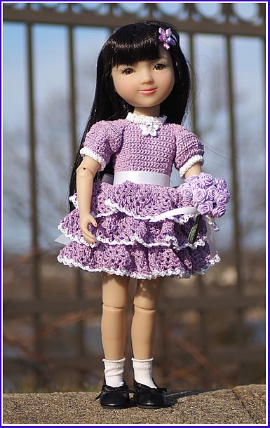 Pretty oriental doll in a ruffled lilac dress